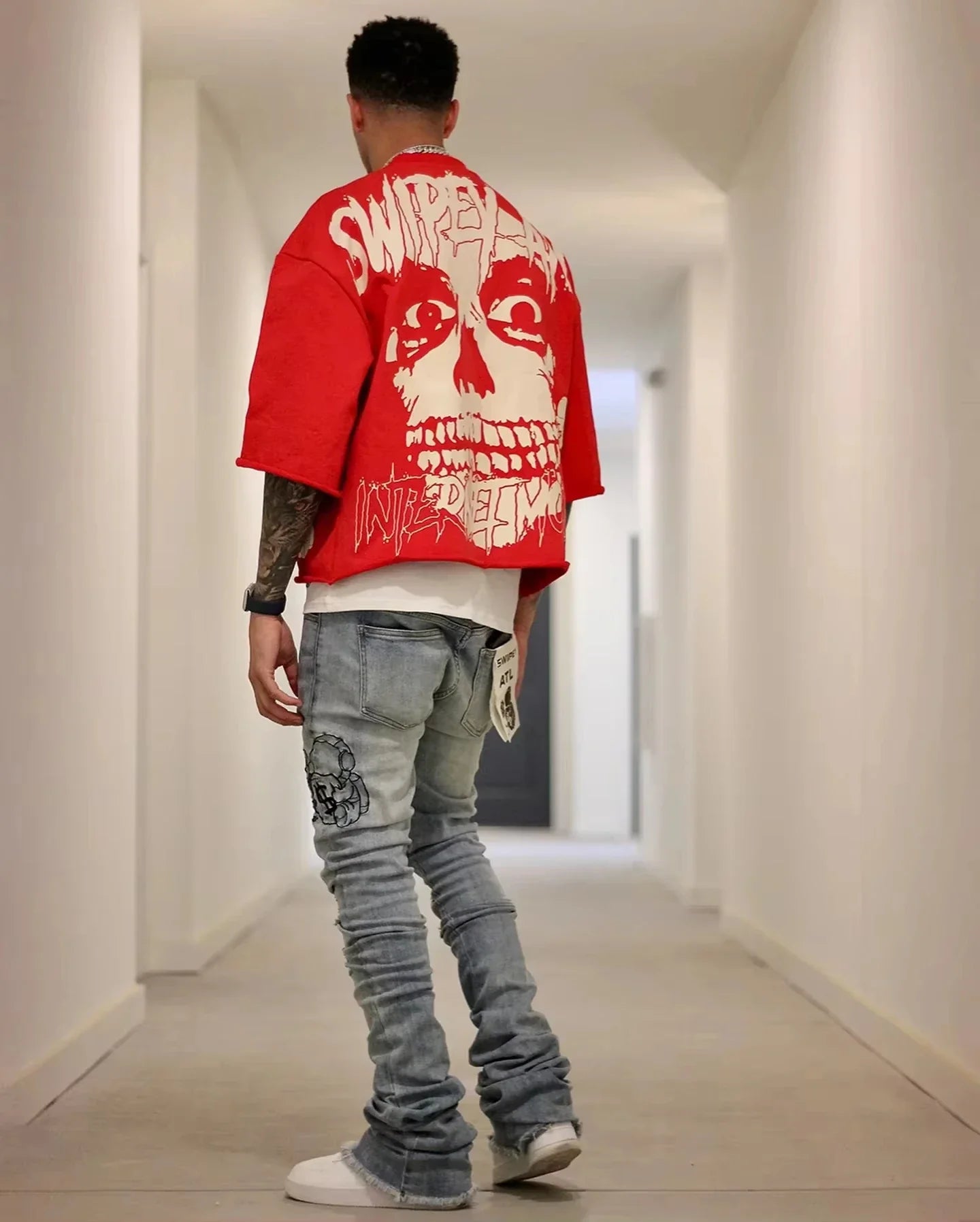Summer Y2K retro gothic skull graphic print men's oversized red t-shirt paired with jeans.